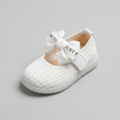 Three-quarter view of white knit baby Mary Jane flat showing bow detail and interior
