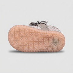Underside tread pattern of a peach-colored baby shoe sole