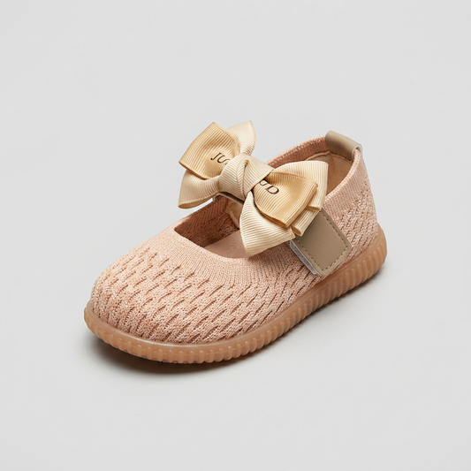 Three-quarter view of peach knit newborn shoe with decorated ribbon bow