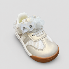 Top-down view of cream metallic toddler sneakers showing floral lace embellishments