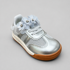 Angled view of toddler metallic silver sneakers decorated with light blue mesh flowers